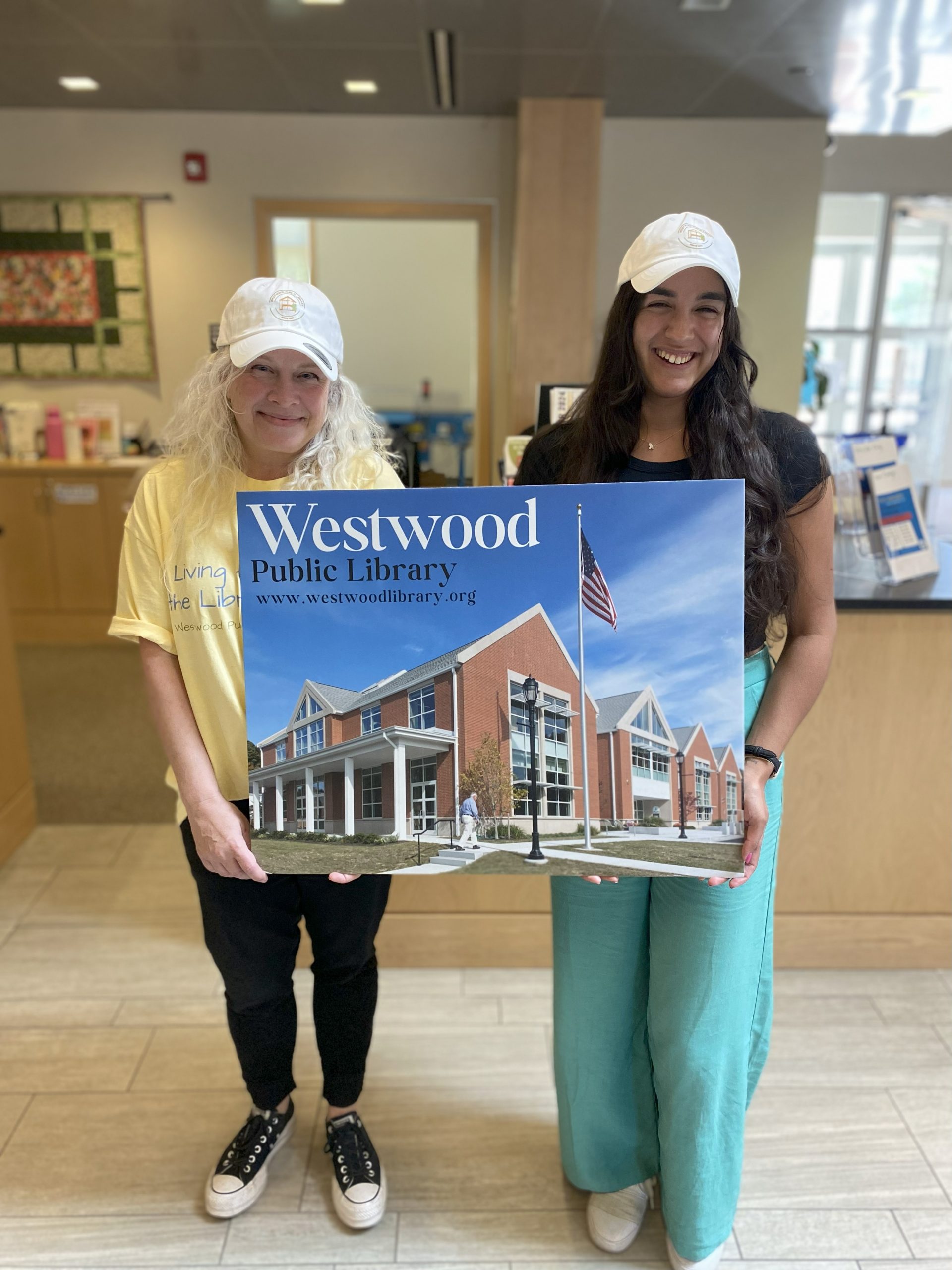 Two people holding a poster